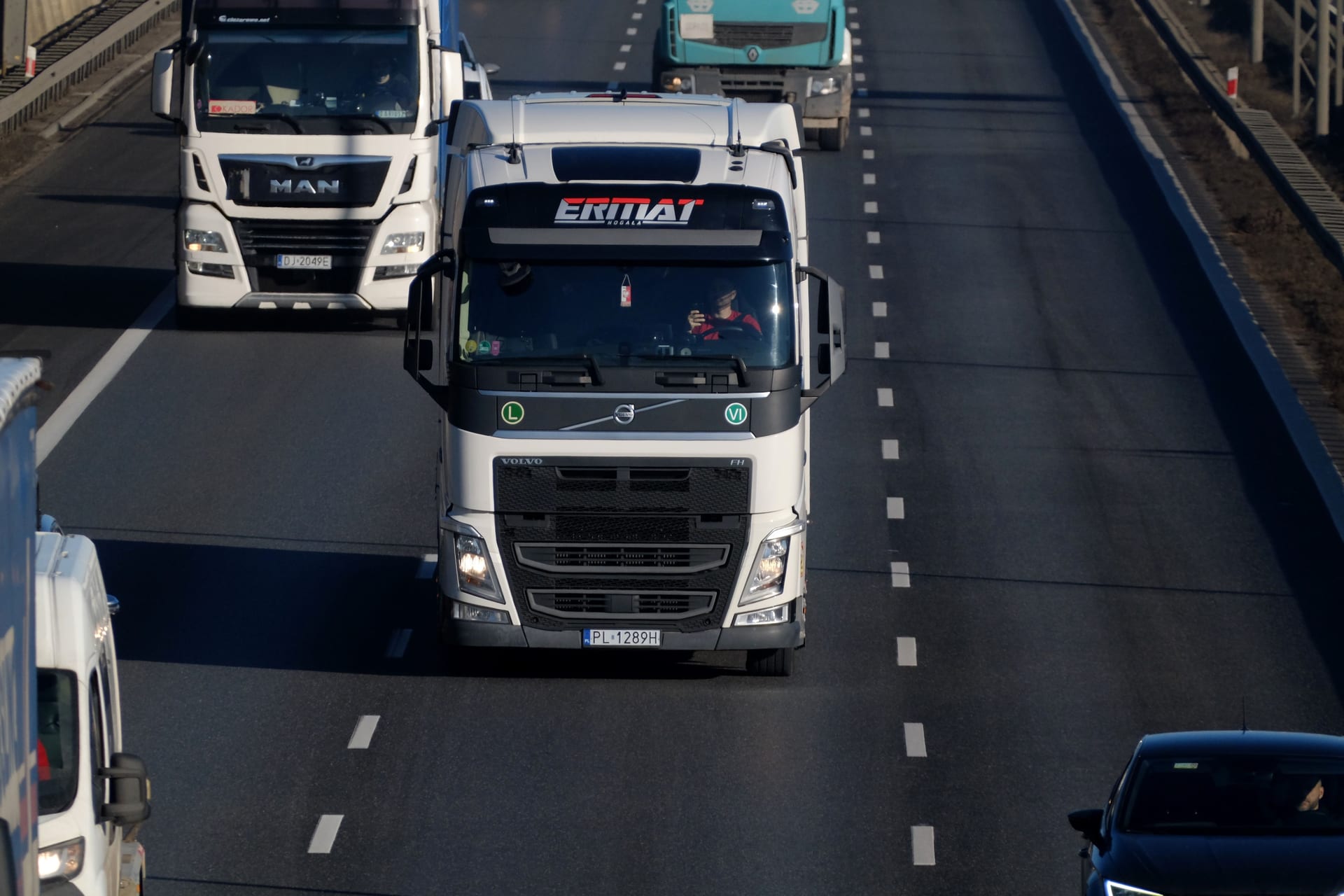 Camion Volvo pe autostradă, cu alte camioane de marfă în trafic